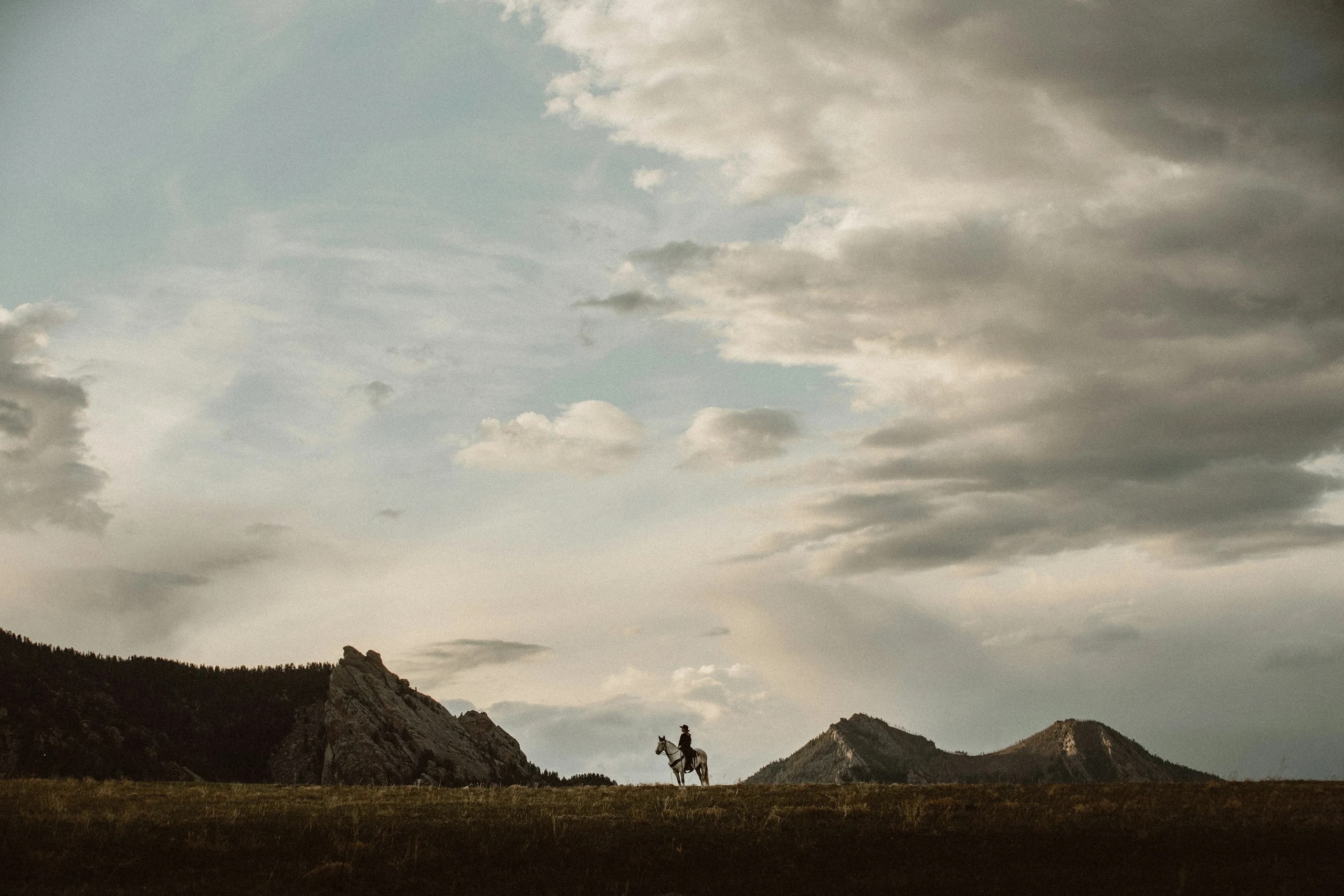 Rider on a white horse in a mountain meadow