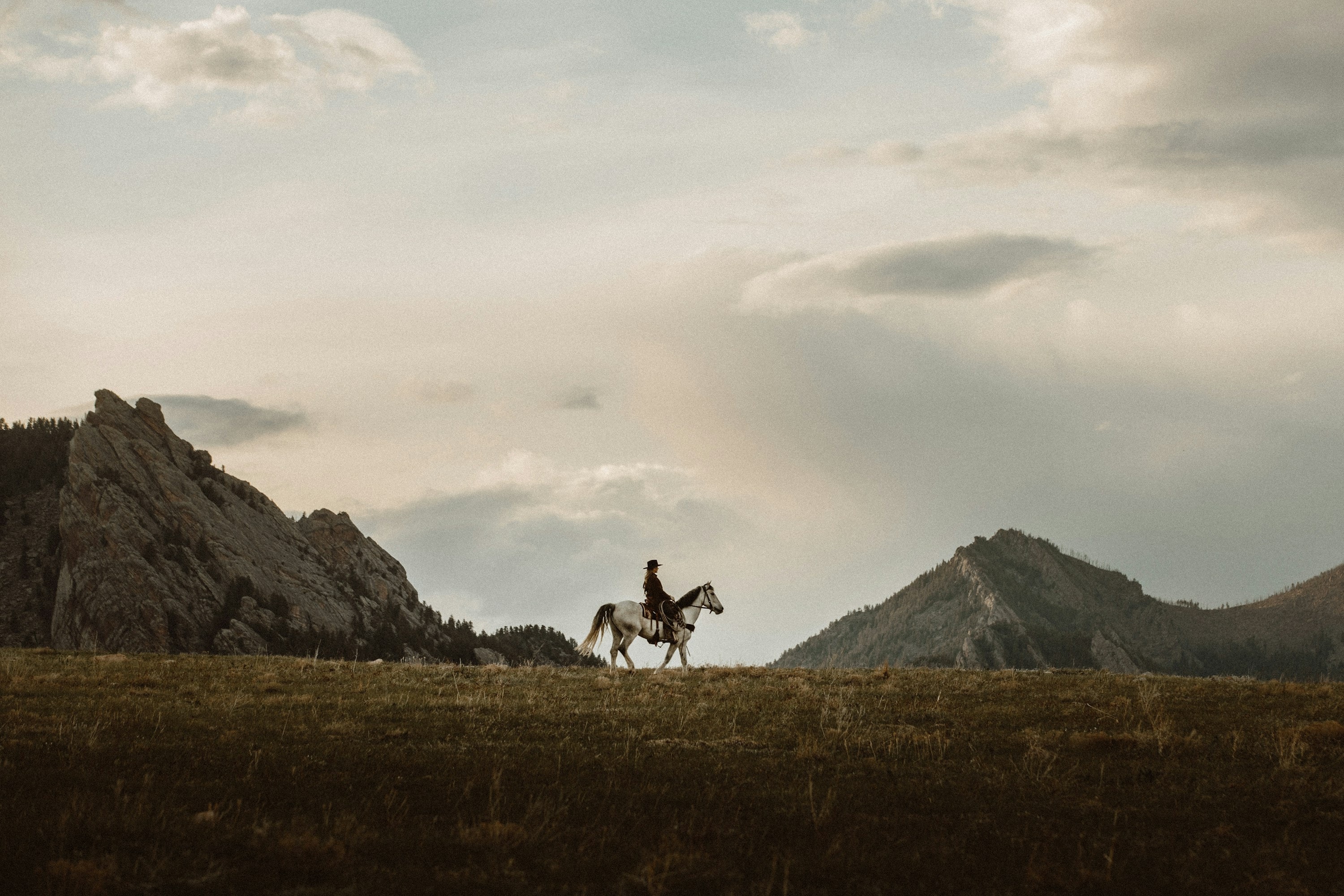 Lone rider crossing open western grassland